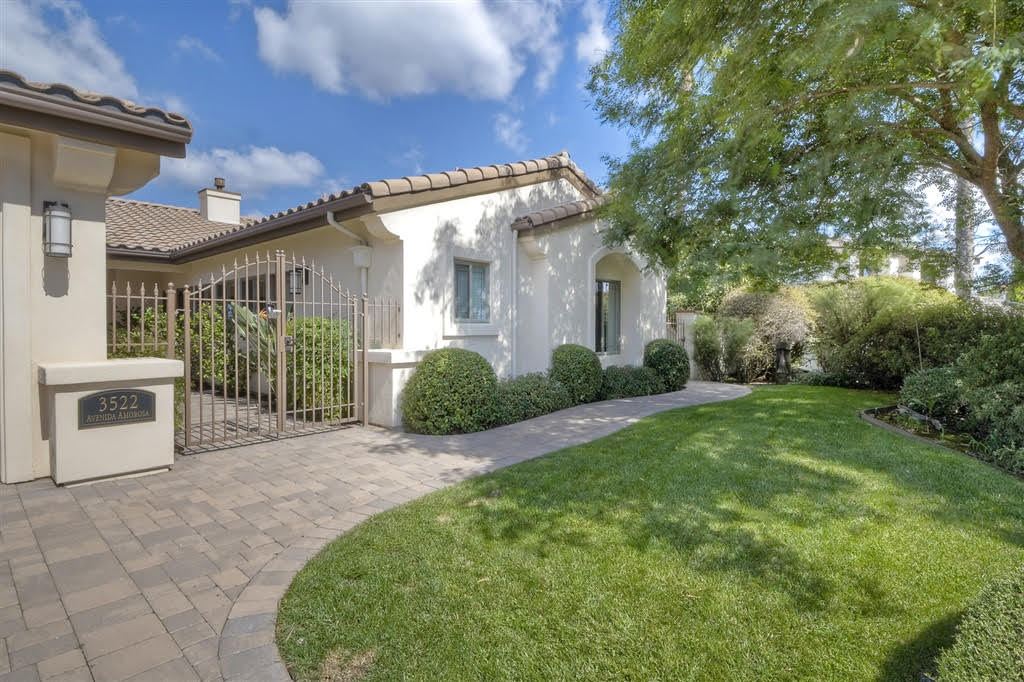 Single-story stucco house with a gated courtyard and front lawn